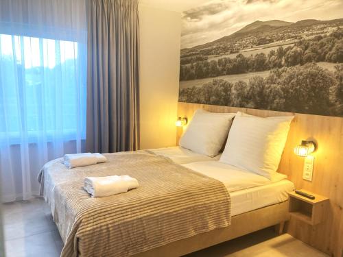 a bedroom with a bed with two towels on it at Apartamenty przy Starym Basenie in Sobótka
