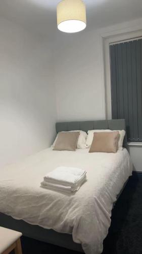 a white bed with towels on top of it at PLUS Properties Westport 1 in Stoke on Trent