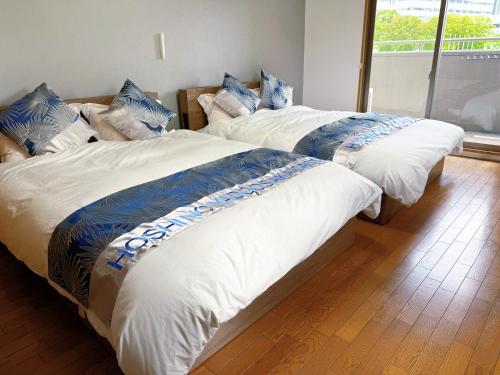 two beds sitting next to each other in a room at 星の宿大阪城 in Osaka