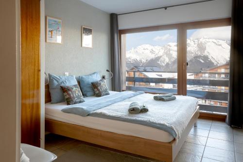 a bedroom with a bed with a view of mountains at Nendaz Olympic Ski-In Ski-Out in Nendaz