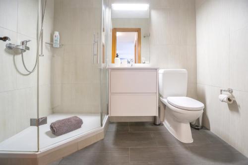 a white bathroom with a shower and a toilet at Christiania Central Nendaz in Nendaz