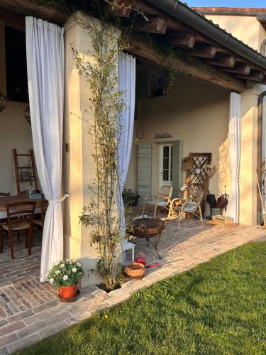 a patio with a white curtain and a table and chairs at Il Glicine - Natural BnB in Castello di Godego