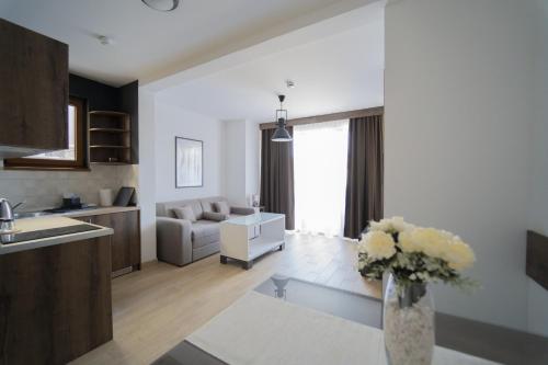 a kitchen and living room with a vase of flowers at Casa D Argento in Veliko Gradište