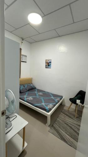 a bedroom with a bed in a room with a table at Thad Transient House - Gensan in General Santos
