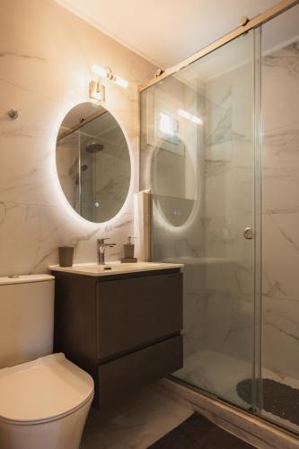 a bathroom with a shower and a sink and a toilet at Dreamy Seaside Loft Pool, Parking, Fast Wifi in Gouvia