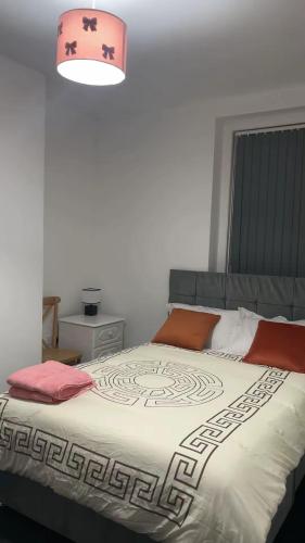 a bedroom with a large bed with a pink lamp at PLUS Properties Westport 2 in Stoke on Trent