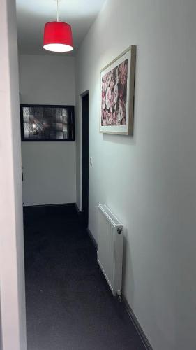 a hallway with a white wall with a picture and a radiator at PLUS Properties Westport 2 in Stoke on Trent