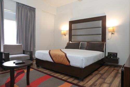 a hotel room with a bed and a chair at Veronica Hotel in Vadodara