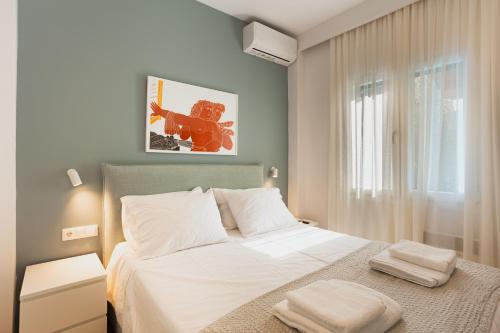 a bedroom with a white bed and a window at Dreamy Seaside Loft Pool, Parking, Fast Wifi in Gouvia