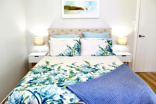 a bed with blue and white sheets and pillows at Goolwa Blue Escape - Beach Spacious Wi-fi in Goolwa