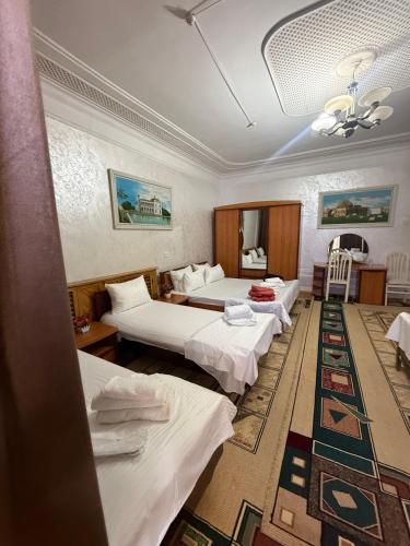 a hotel room with four beds and a table at BUKHARA Air Hostel in Bukhara