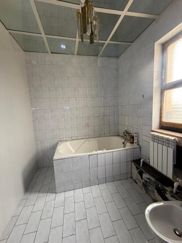 a white bathroom with a tub and a sink at BUKHARA Air Hostel in Bukhara