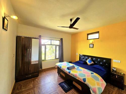 a bedroom with a bed and a ceiling fan at Kolaveri Homes in Bīr