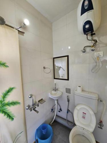 a bathroom with a toilet and a sink at Kolaveri Homes in Bīr