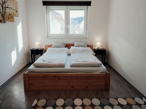 a bed in a room with two lamps on two tables at Italia House in Fót