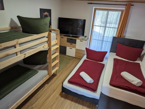a room with two bunk beds and a flat screen tv at Ferienwohnung Alpenblick Dorner - VON MARTIN in Oberreute