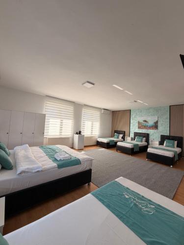 a large room with two beds and couches in it at Hotel Green Garden in Bucharest
