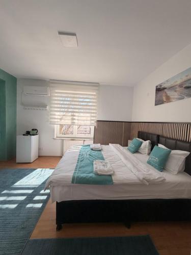 a bedroom with a large bed with blue pillows at Hotel Green Garden in Bucharest