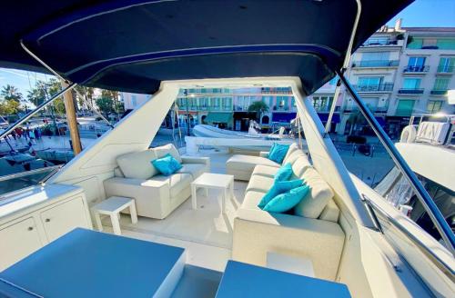un bateau avec des coussins bleus et des chaises sur un bateau dans l'établissement Yacht FALCON FIVE, à Cannes