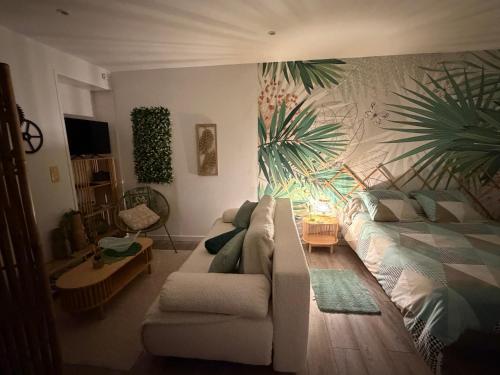 a living room with a couch and a bed at Studio ambiance ZEN in Riantec