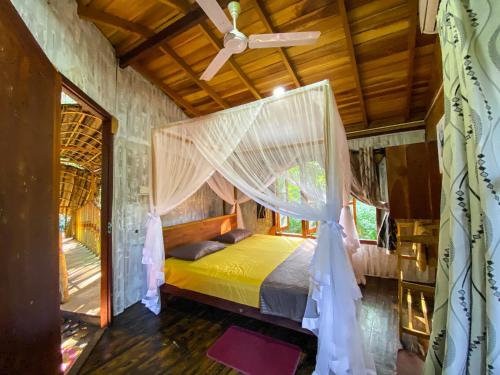 a bedroom with a bed with a mosquito net at Matara Eco Friendly Treehouse in Matara