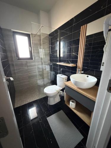a bathroom with a white toilet and a sink at GRAND Caciulata in Caciulata