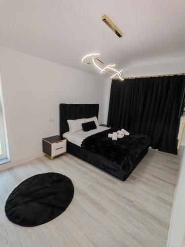 a bedroom with a black bed and a black rug at Dream Home in Giroc