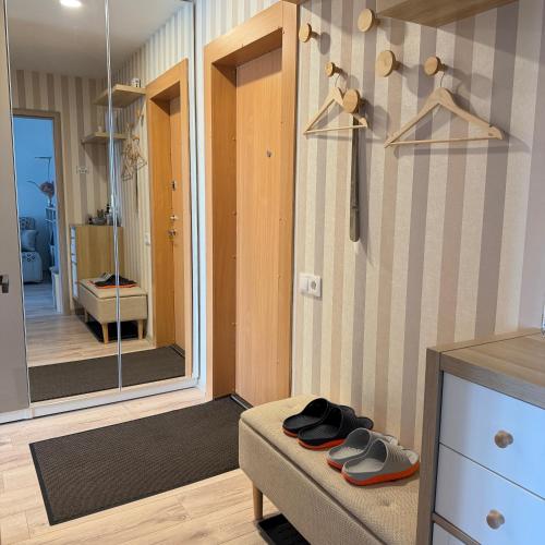 a room with a mirror and a pair of shoes at LIUxSAU apartmentai in Mažeikiai