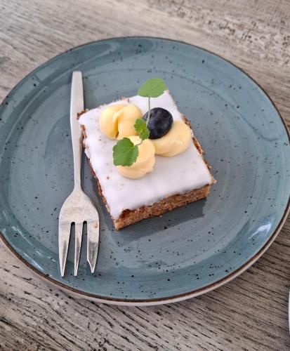 a piece of cake on a blue plate with a fork at CHALET36 in GROU in Grou