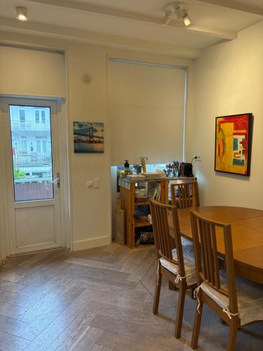 a dining room with a table and chairs and a window at Appartement in Stadsdeel West in Amsterdam