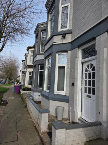 a row of houses with blue trim on a street at Ince House in Liverpool