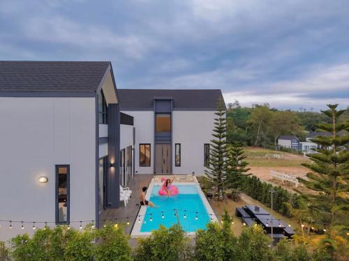 a house with a swimming pool in front of it at I-DIN POOL VILLA khaoyai in Ban Nong Song Hong