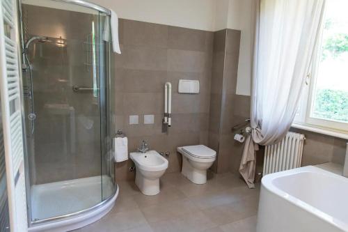 a bathroom with a shower and a toilet and a sink at Villa Fiore in Novilara