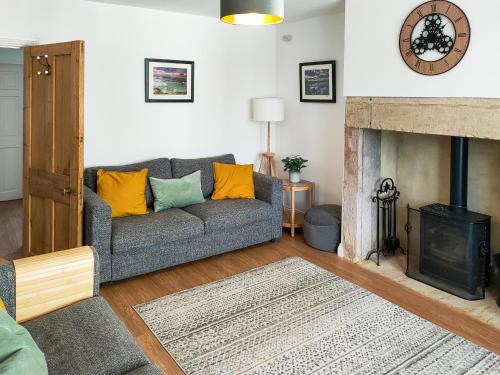 a living room with a couch and a fireplace at Cygnet Cottage in Warkworth