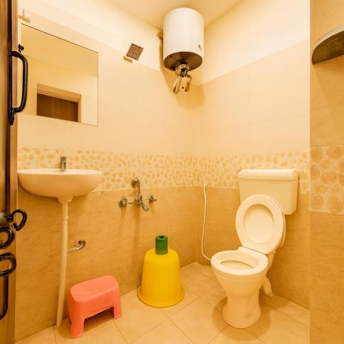 a bathroom with a toilet and a sink at Mysore Couple Friendly at 999 in Mysore