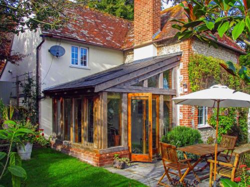 an extension to a house with a table and an umbrella at Pensway in Burpham