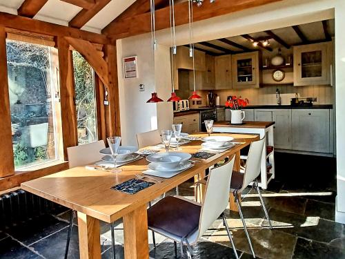 a kitchen with a wooden table and chairs in a kitchen at Pensway in Burpham
