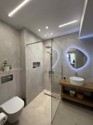 a bathroom with a shower and a toilet and a sink at Blue Breeze in Paralia Vrachou