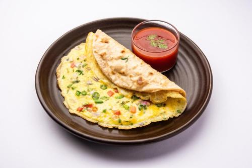 a black plate with a omelet and a salsa at Hotel lalu in Rāmechhāp