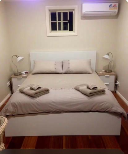 a bedroom with a bed with two towels on it at Dees Front Studio Room in Hazelbrook