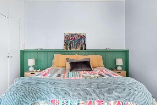 a bedroom with a bed with a green headboard at Coorabin in Orange
