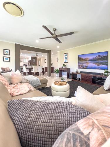 a living room with two couches and a ceiling fan at Solis Acreage Escape in Advancetown