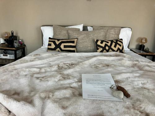 a bed with a white blanket and a stuffed animal on it at B&B My Suite Home in Bruges