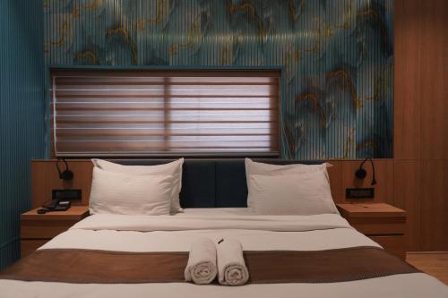 a bedroom with a large bed with white pillows at Kratos Lifestyle in Surat