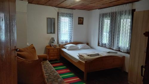 a small bedroom with a bed and a window at Мома Елена in Makhalnitsi