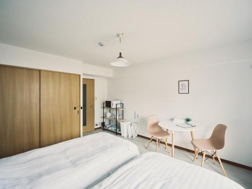 a bedroom with a bed and a table and chairs at vetta kumamoto suizenji2 308 in Kumamoto