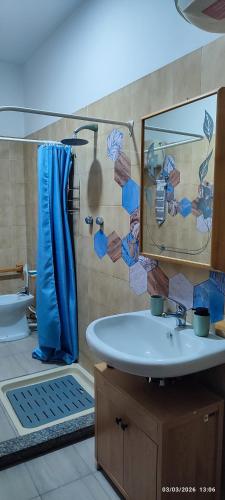 a bathroom with a sink and a mirror and a tub at ToMa House in Pellaro