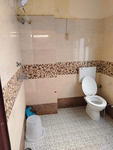 a bathroom with a toilet in a room at New Mewar Darshan in Udaipur