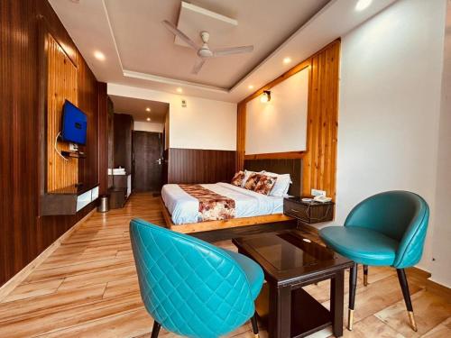 a hotel room with a bed and a desk and a chair at Sawer Fan Resort in Mussoorie