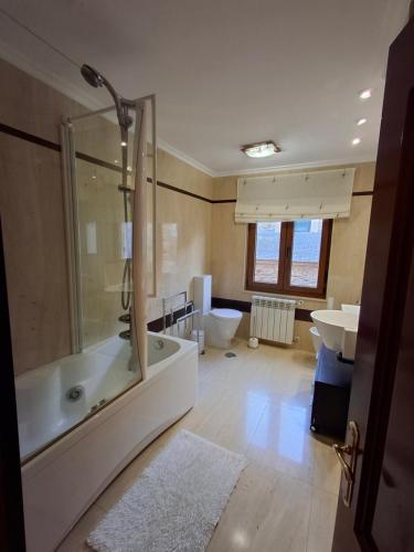 a bathroom with a tub and a sink at As Pitas 1 in Tapia de Casariego
